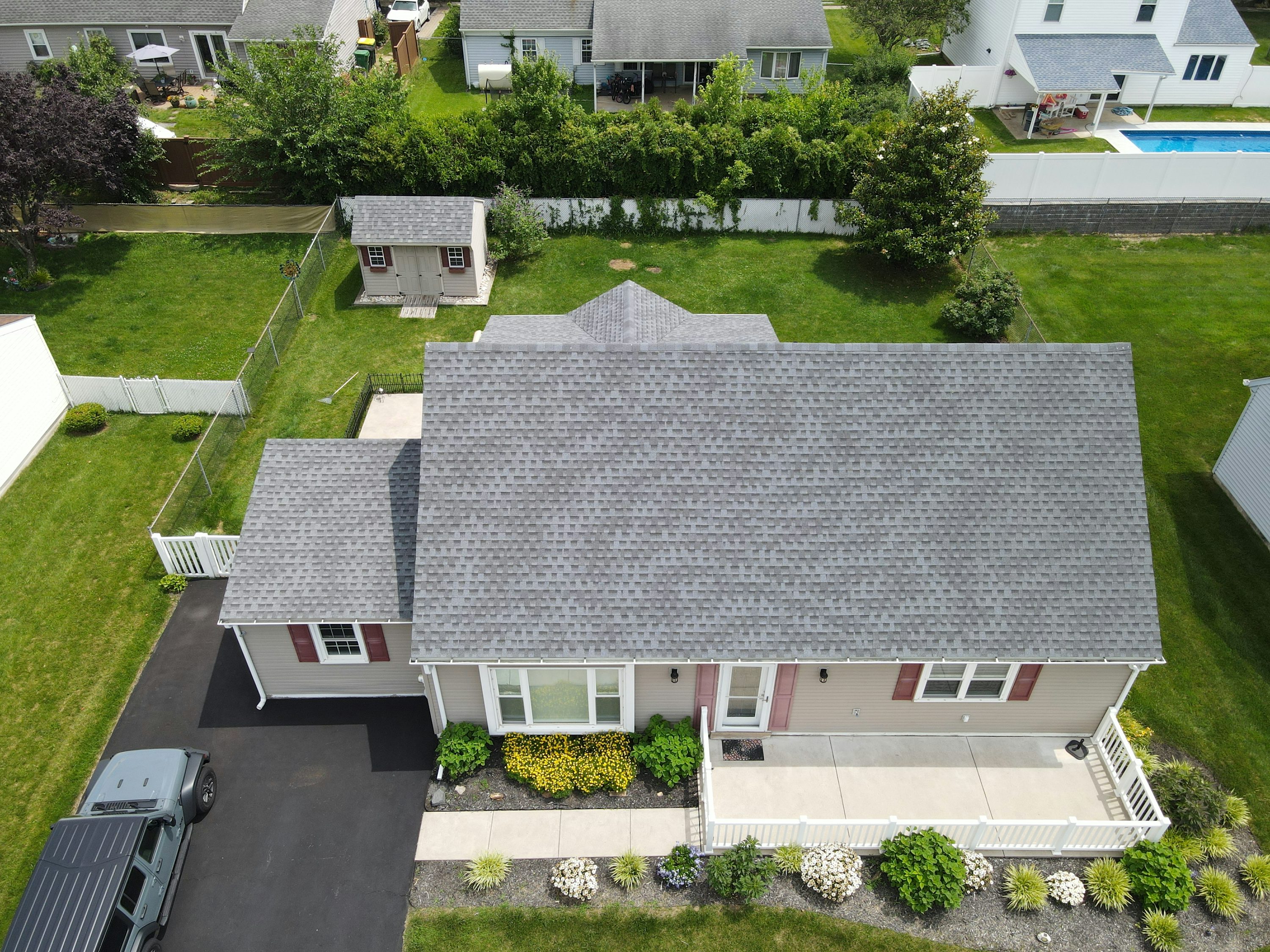 Aerial view of a suburban home with a broad gray roof